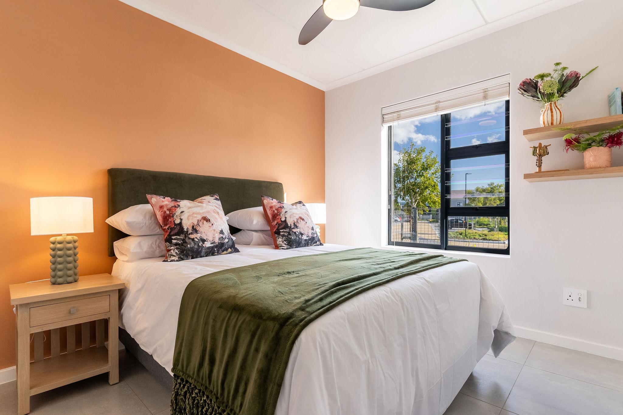 Cape Perlant main bedroom with a double bed and orange feature wall