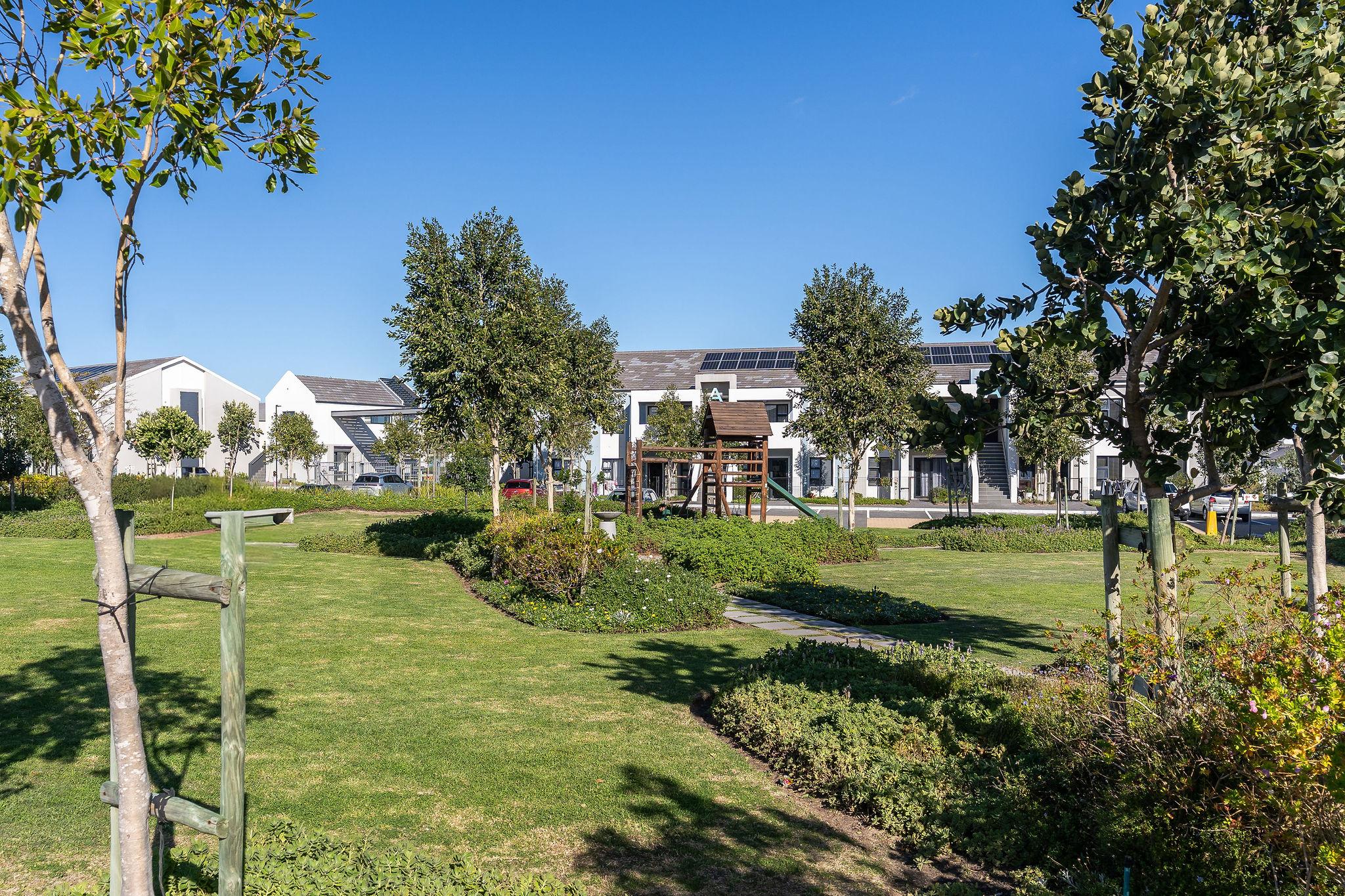Landscaped communal gardens at Quinta Estate with a children's play area