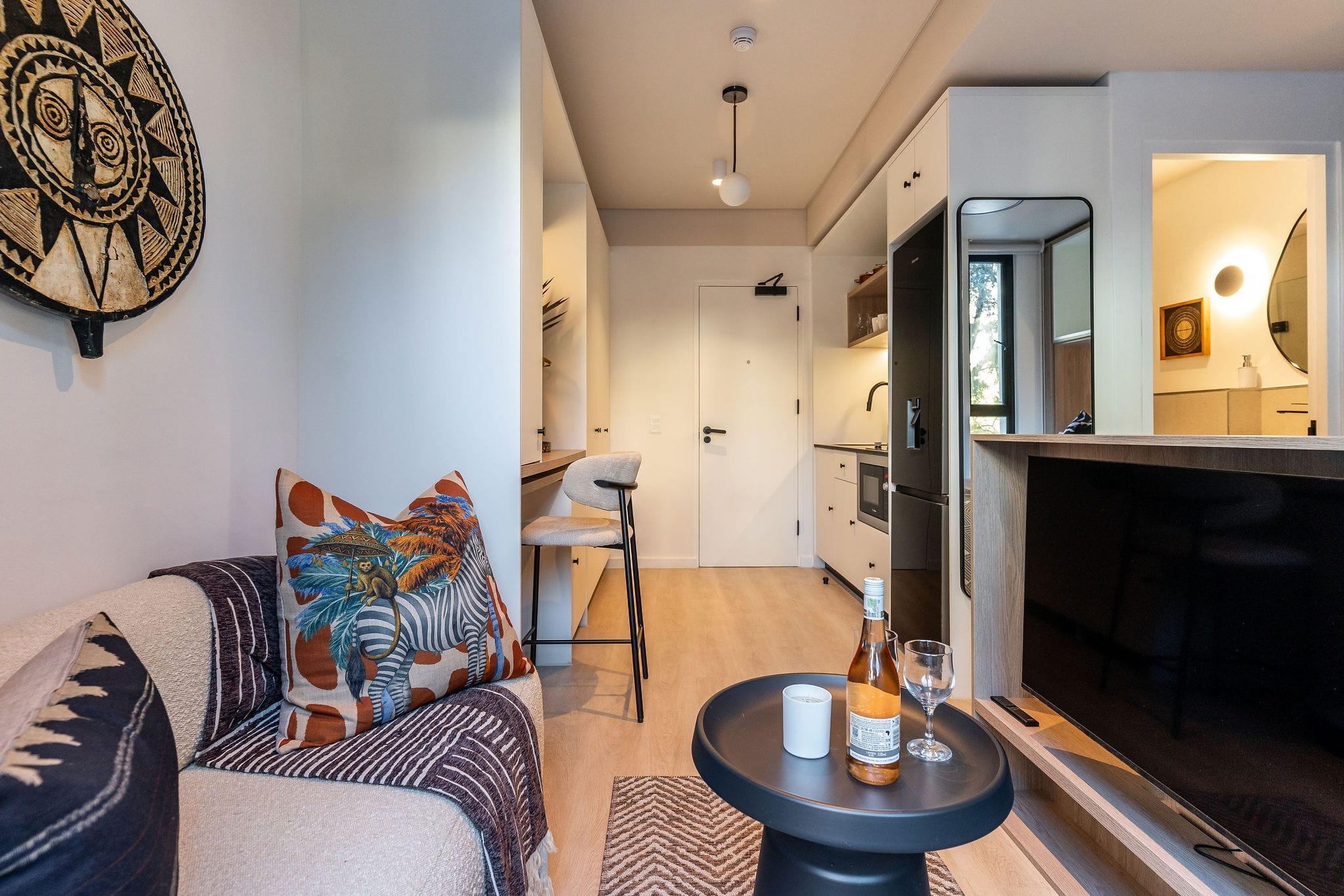 Centrepark living area with a patterned throw sofa and wall-mounted TV