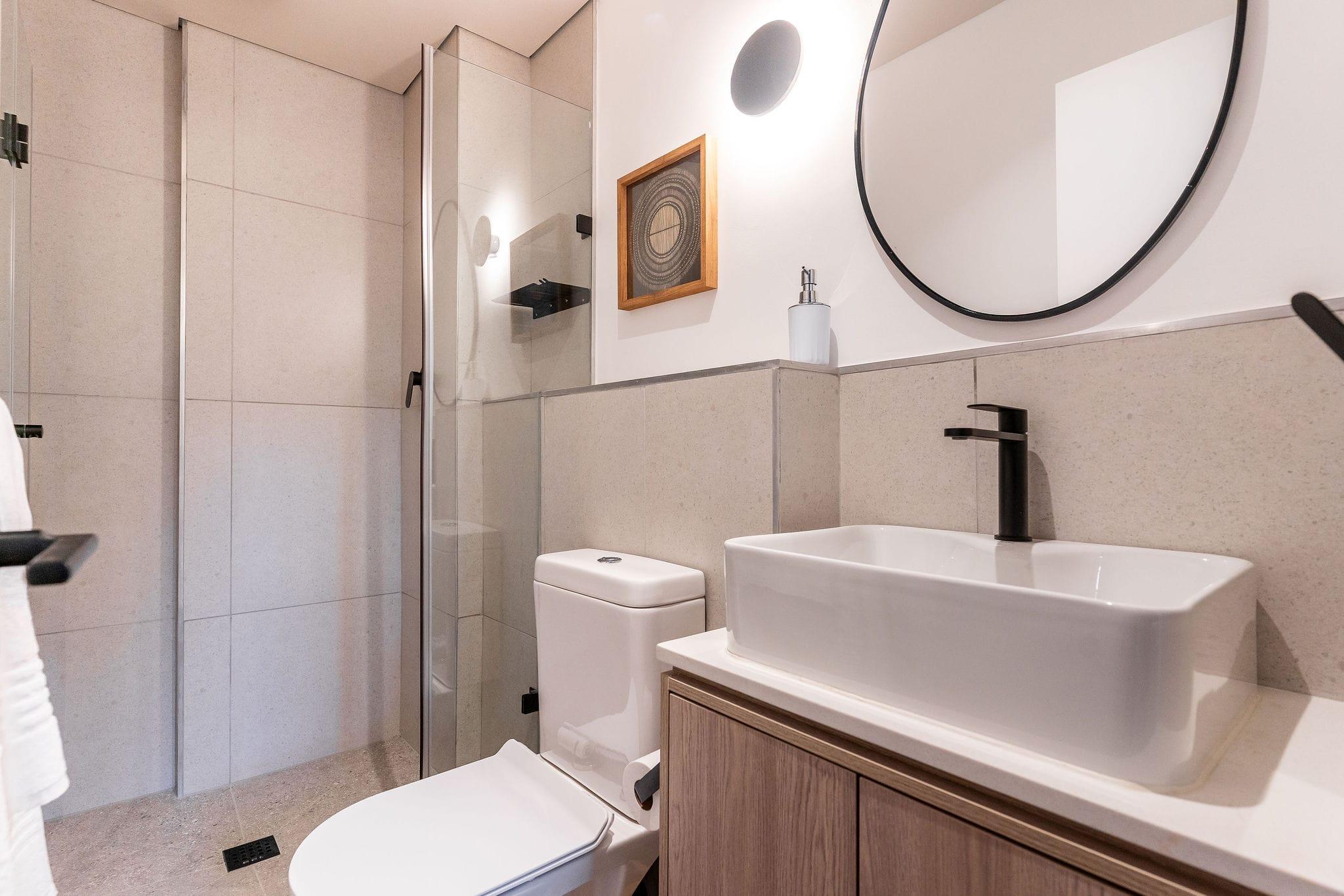 Centrepark bathroom with a rectangular vessel sink and glass-enclosed shower