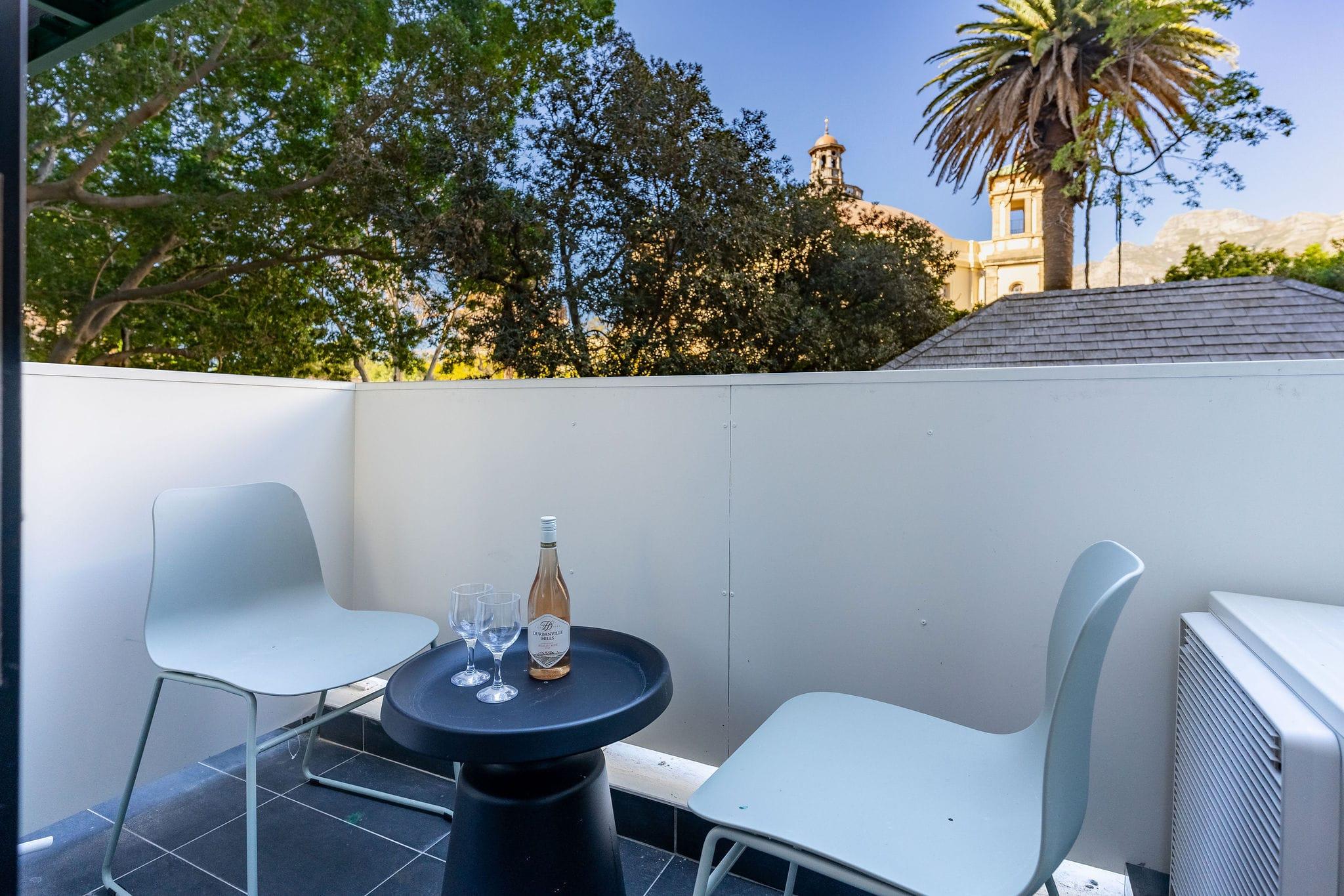 Private balcony at Centrepark with bistro seating and a view of a historic church