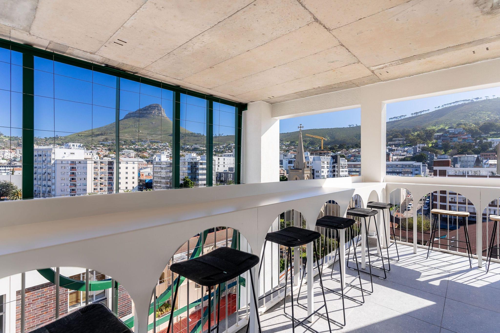Ten on V rooftop bar seating at the clubhouse and shared workspace along an arched balustrade overlooking Lion's Head
