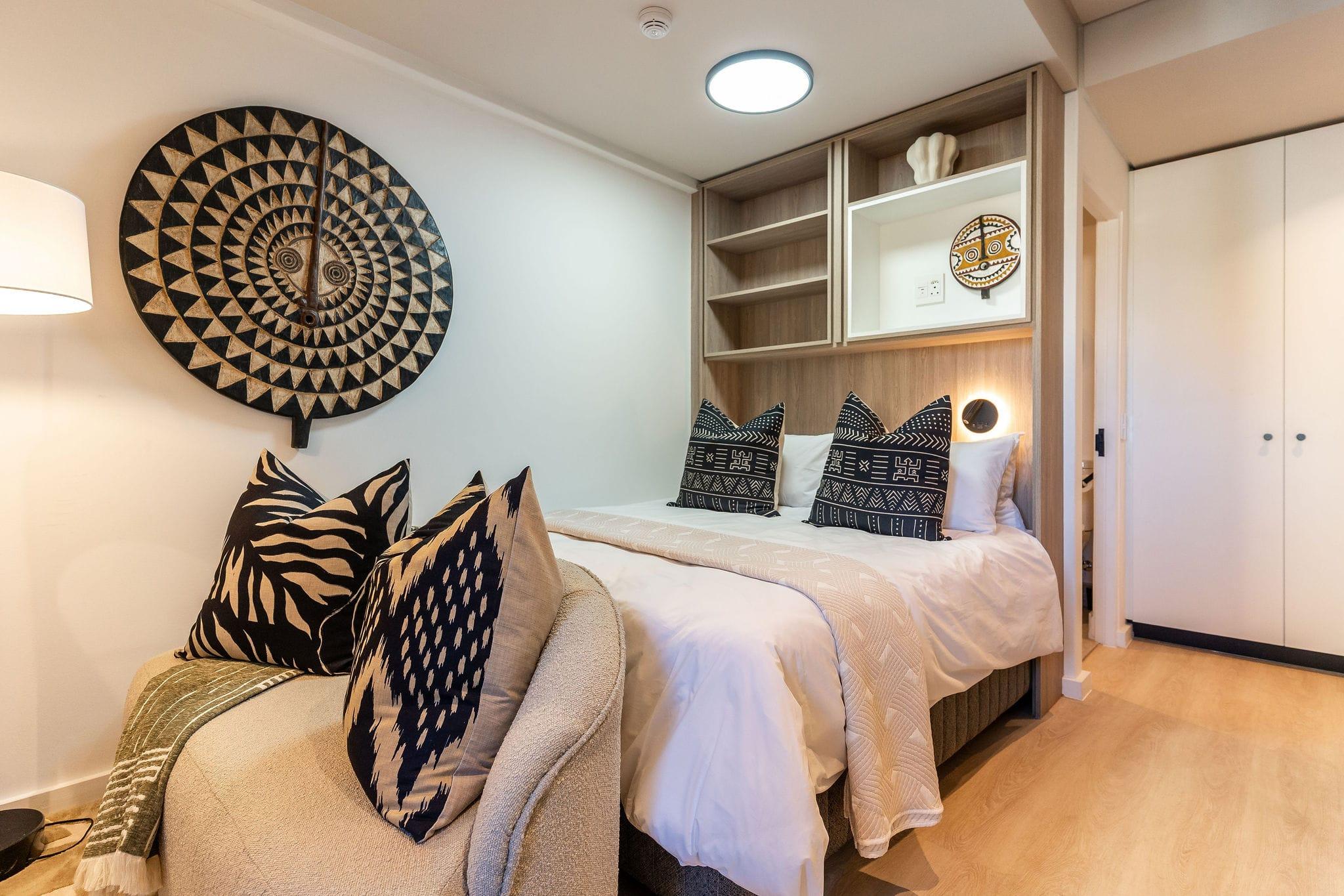 Mountainview bed nook with a large African mask and patterned scatter cushions