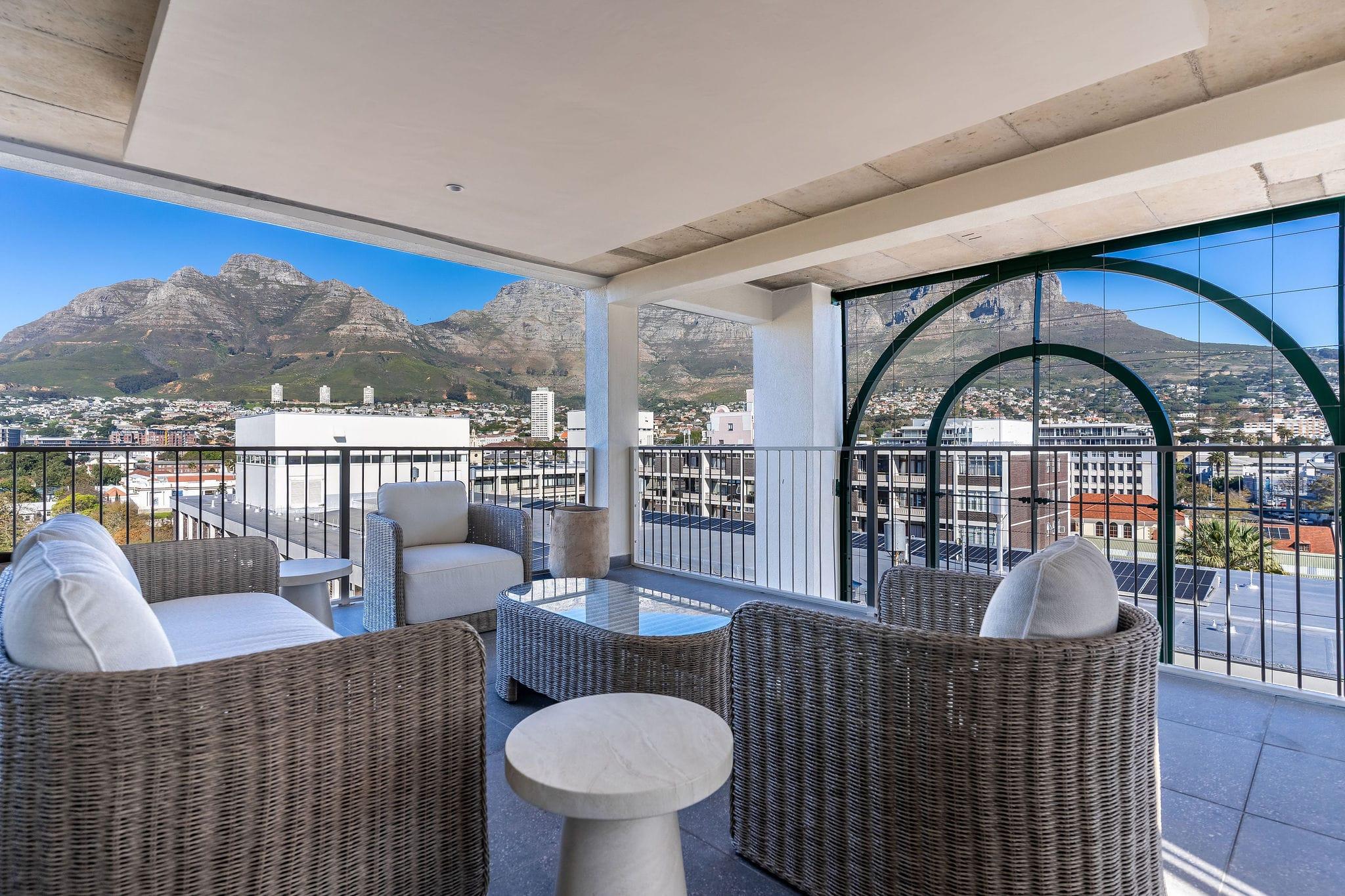 Covered rooftop lounge clubhouse with wicker armchairs overlooking Table Mountain